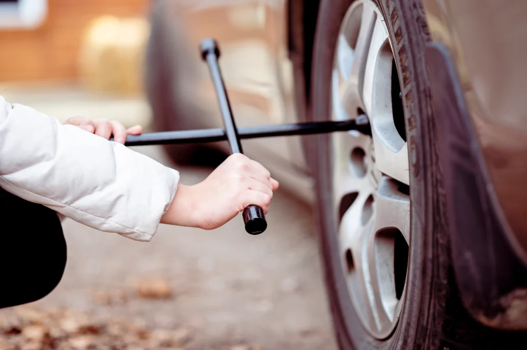 A professional from aone roadside assistance doing tyre replacement service